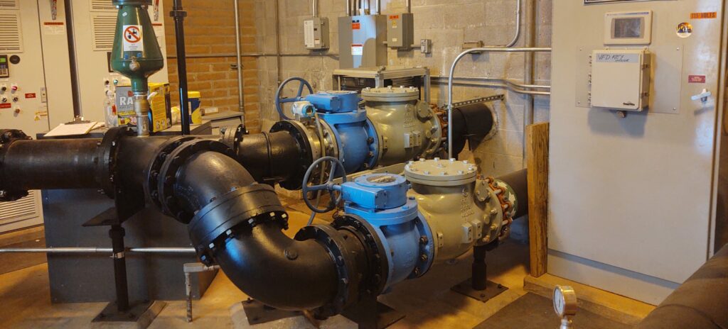 Industrial boiler room with large pipes, valves, and control panels on concrete walls in Sedona, AZ.