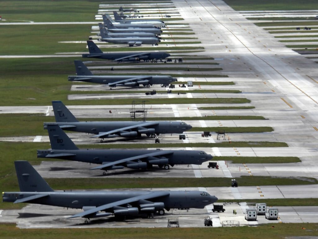 Rows of large military aircraft parked on a vast airstrip at Barksdale Air Force Base, surrounded by grassy fields.