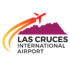 Logo of Las Cruces International Airport, featuring a stylized airplane ascending over a purple mountain with orange and yellow fuel trails.